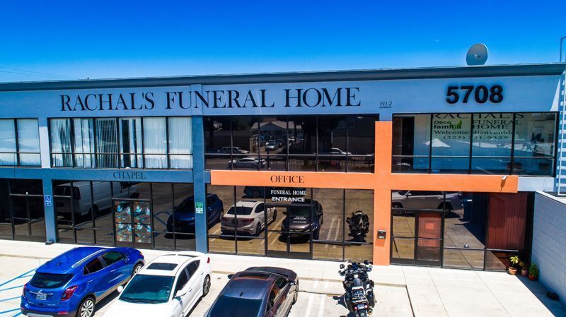 image of front door of east olympic funeral home with glass and a wooden door and flowers