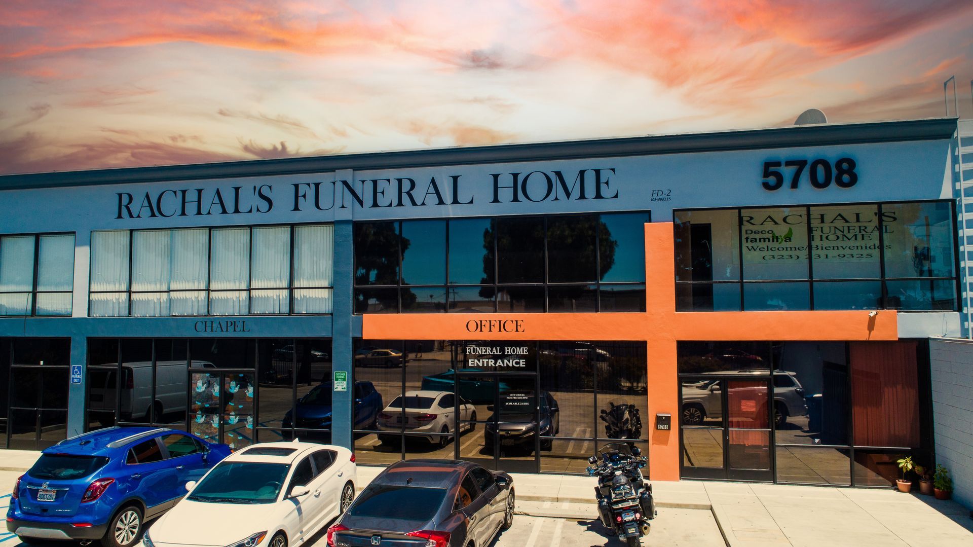A funeral home with cars parked in front of it