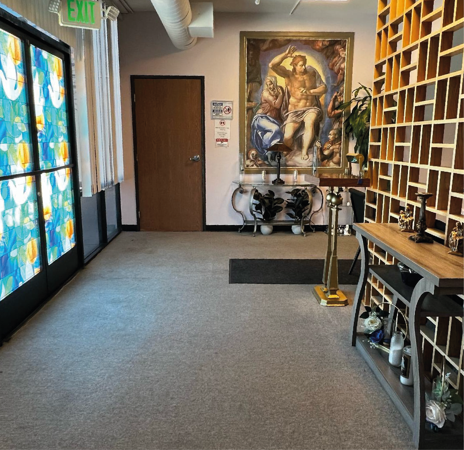 A hallway with a table and chairs and a painting on the wall.