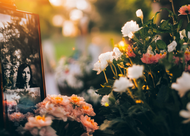 There is a picture of a woman in a frame surrounded by flowers.