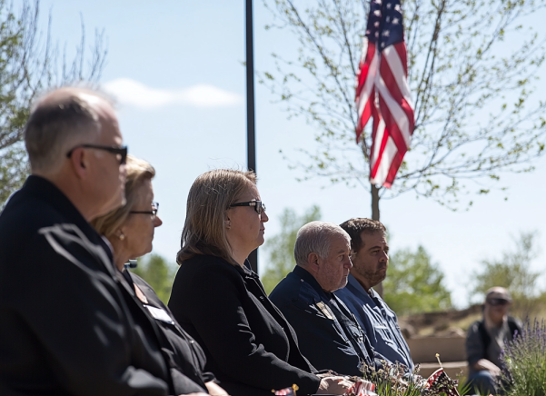 A group of people are sitting in front of an american flag.