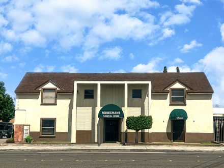 A white building with a green awning on the side of it