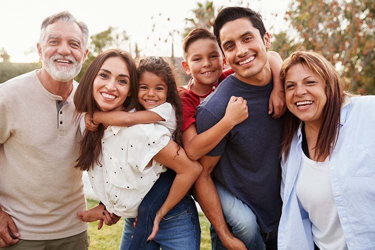 A large family is posing for a picture in a park.