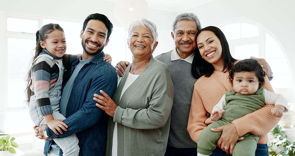 A large family is posing for a picture together in a living room.