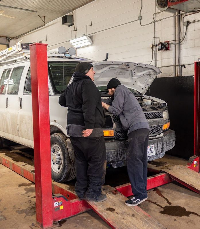 Two mechanics examining a van engine in a garage | Fred's Brake and Alignment