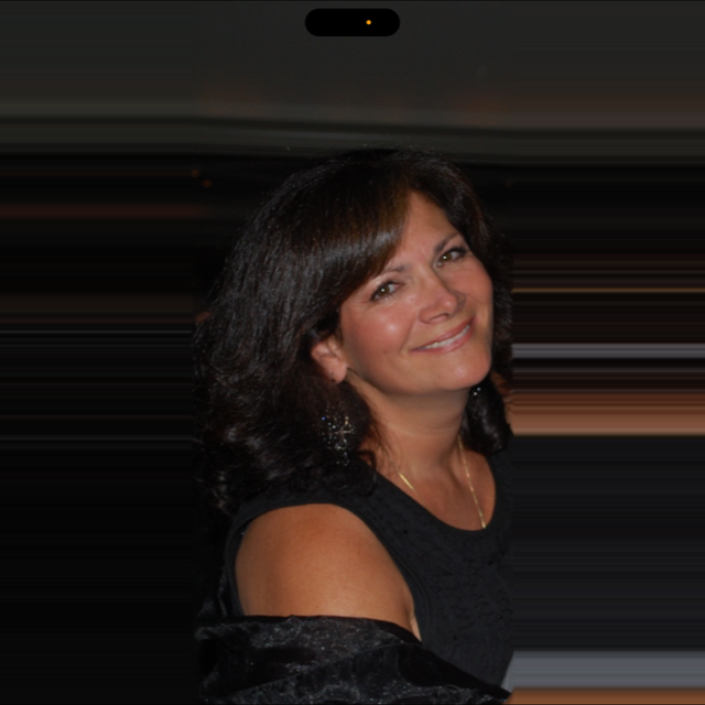 A woman in a black dress smiles for the camera