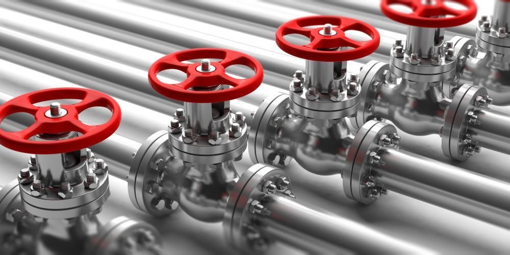 A Row of Metal Pipes With Red Valves on Them — Approved Plumbing Service in Howard, QLD