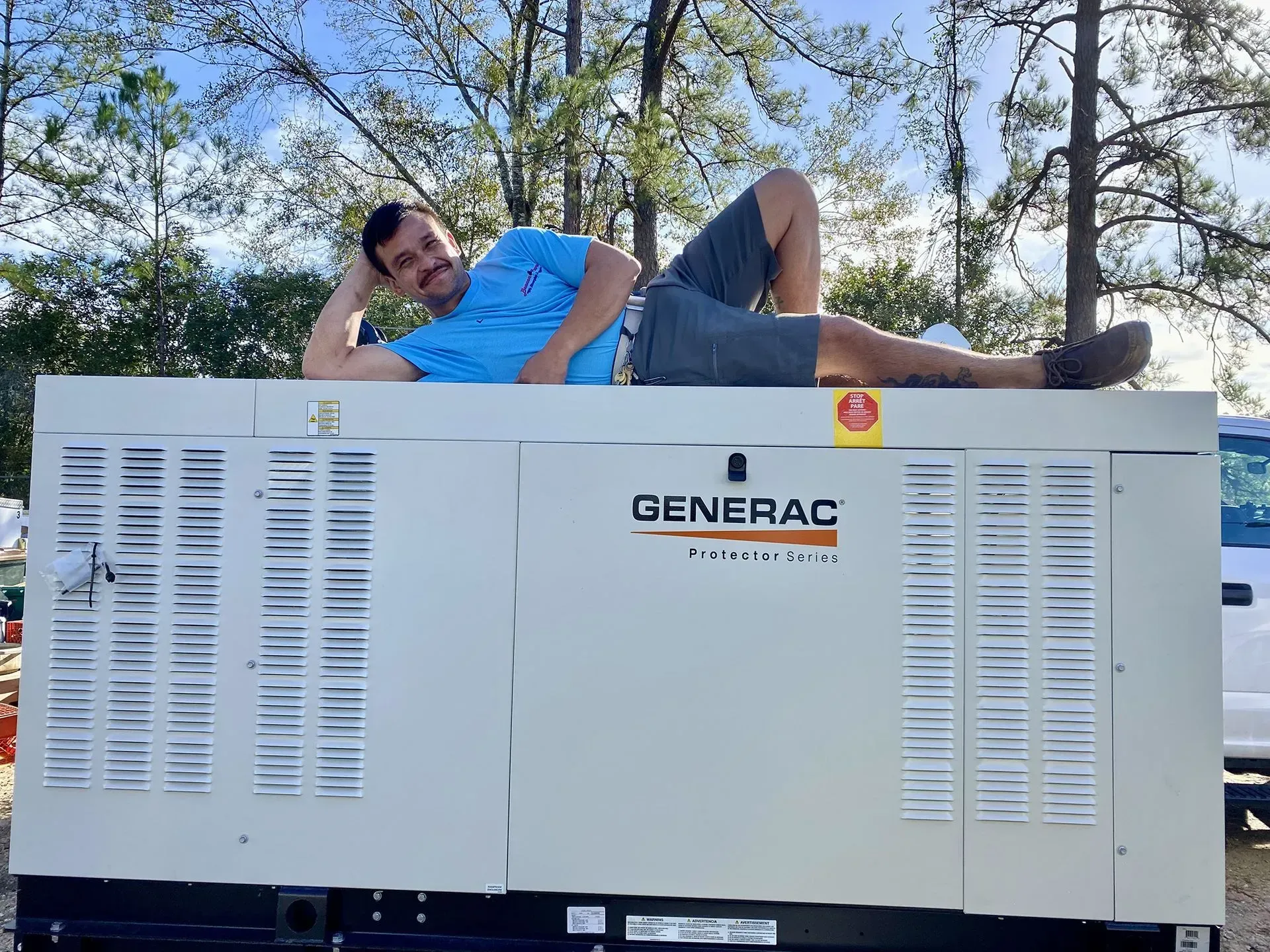 A man is laying on top of a generator.