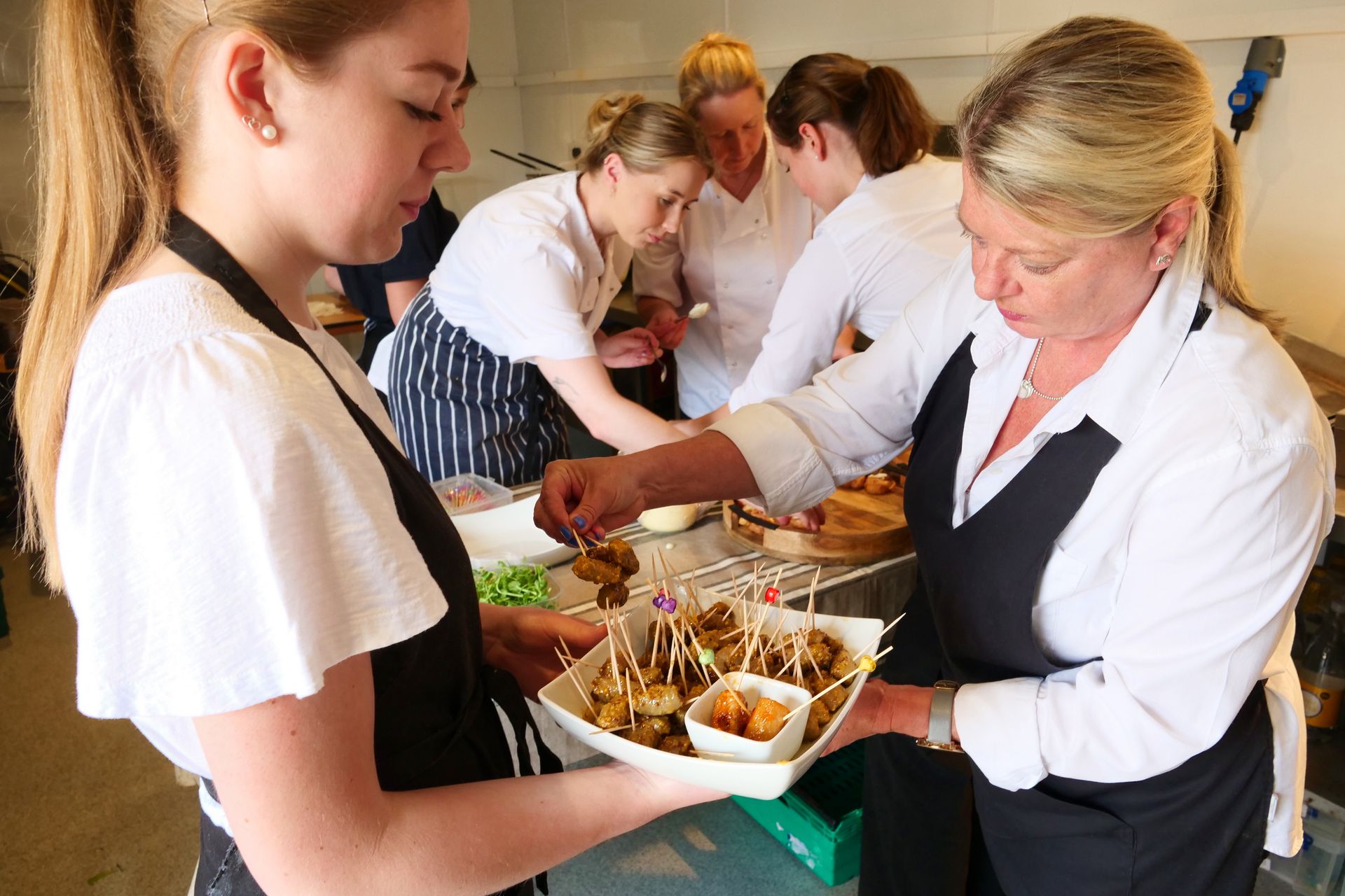A group of people are preparing food in a kitchen.