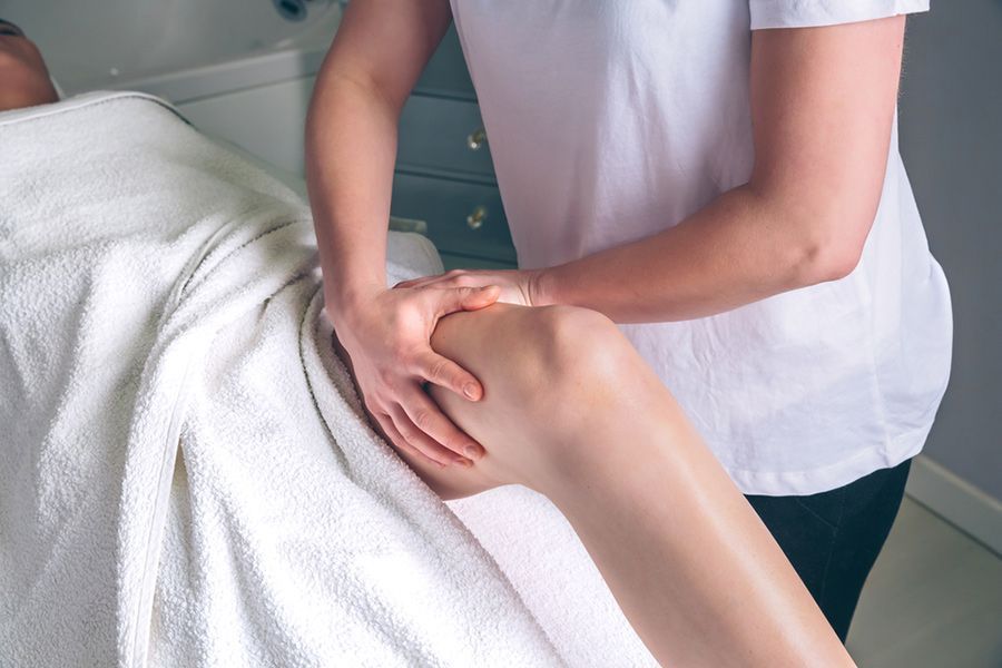 A Woman Is Getting a Massage on Her Leg in A Spa — Align Health Therapies in Thirroul, NSW