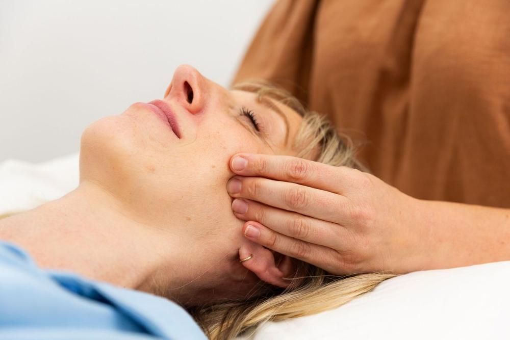 A Woman is Getting a Massage on Her Face — Align Health Therapies in Woonona, NSW