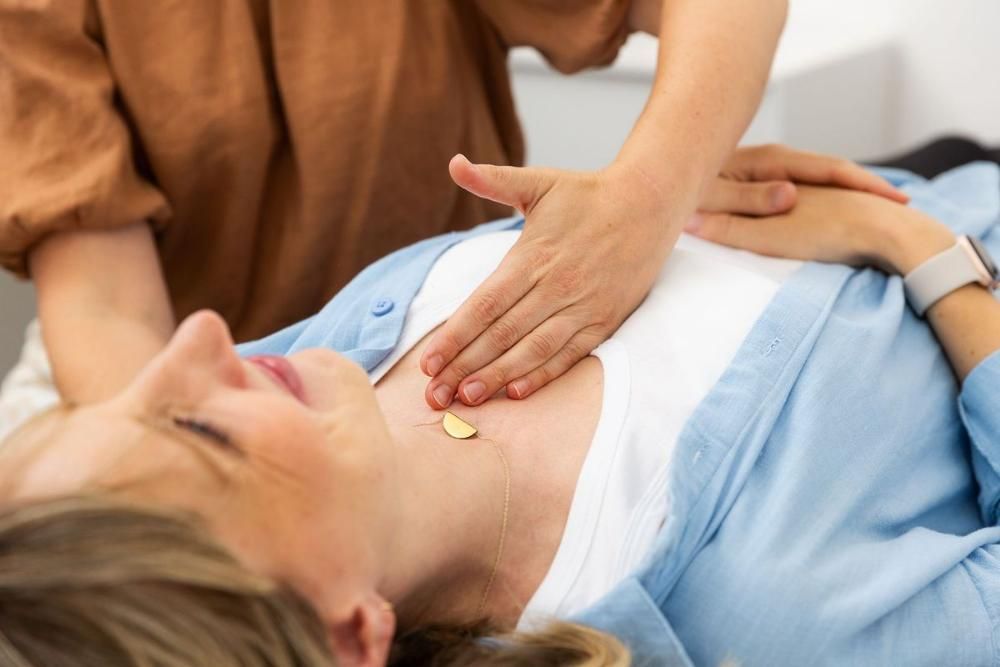 A Woman is Laying on Her Stomach With Her Hands on Her Chest — Align Health Therapies in Woonona, NSW