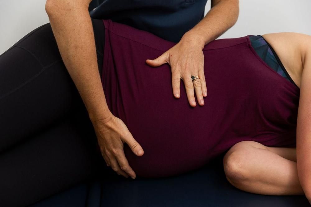 A Woman is Laying on a Table Getting a Massage From a Doctor — Align Health Therapies in Woonona, NSW