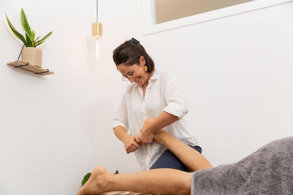 A Woman is Giving a Person a Massage in a Room — Align Health Therapies in Woonona, NSW