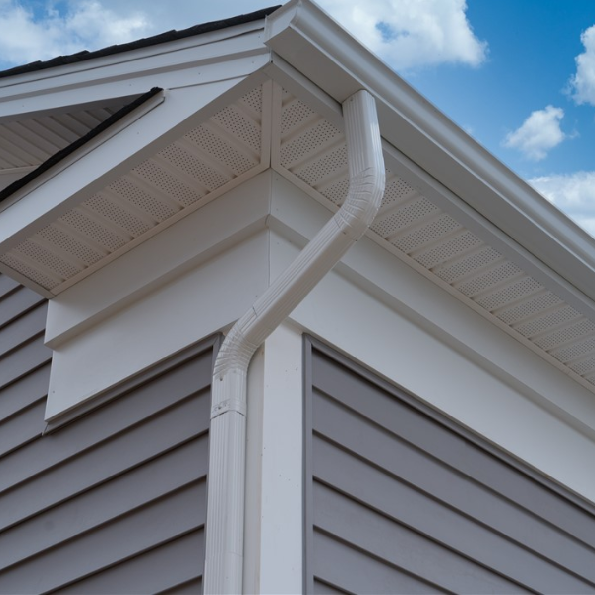 White gutter system on gray siding.