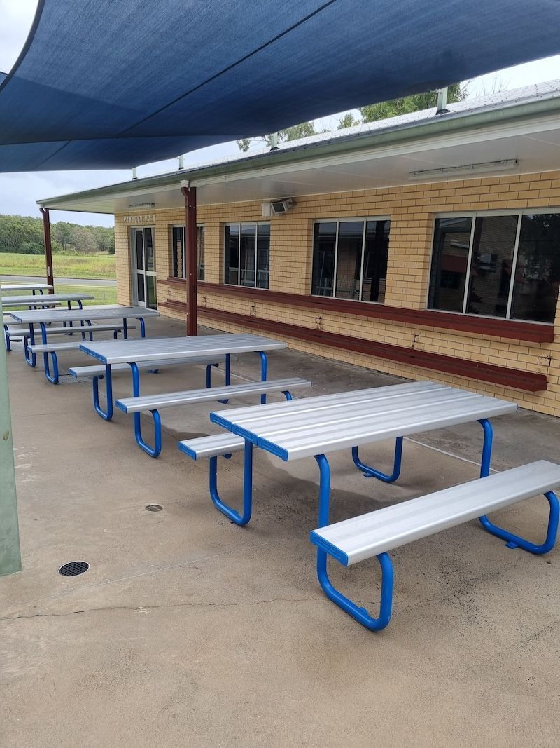 A Man Is Cleaning A Window With A Squeegee In An Office — Cap Coast Pressure Cleaning in Lammermoor, QLD