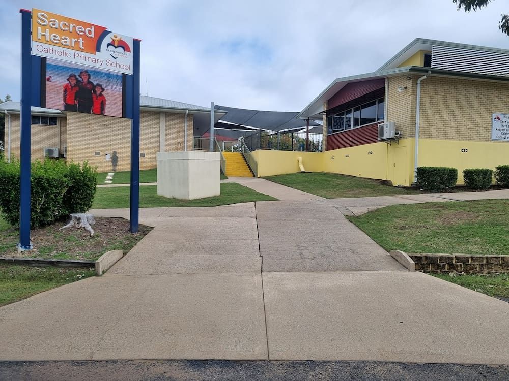 A Sign That Says Sacred Heart Is In Front Of A Building — Cap Coast Pressure Cleaning in Lammermoor, QLD