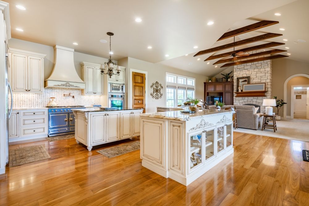 A large kitchen with a large island in the middle of it and hardwood floors.