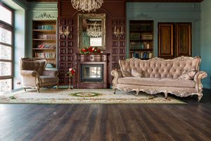 A living room with a couch , chair , fireplace and bookshelves.