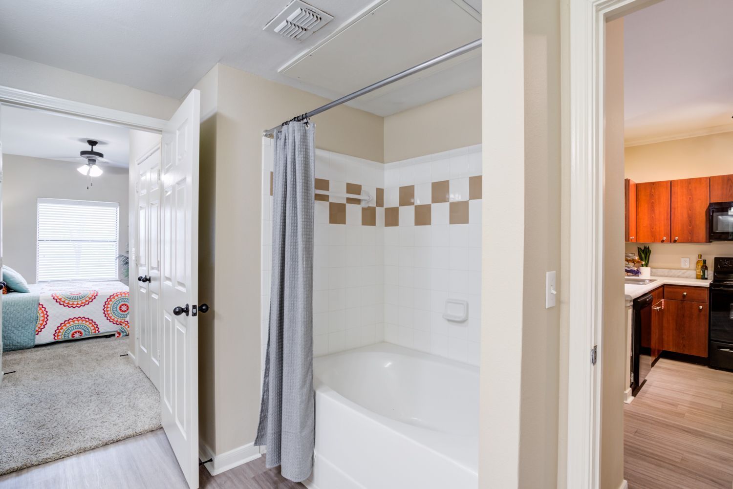 Bay Vista modern bedroom with bed, curtain, wall art, night stand, and ceiling fan.