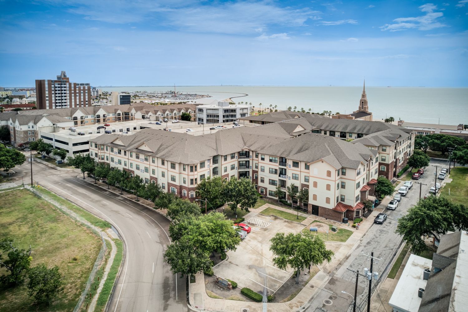 Picnic area with tables, grill, and apartment buildings under a blue sky.