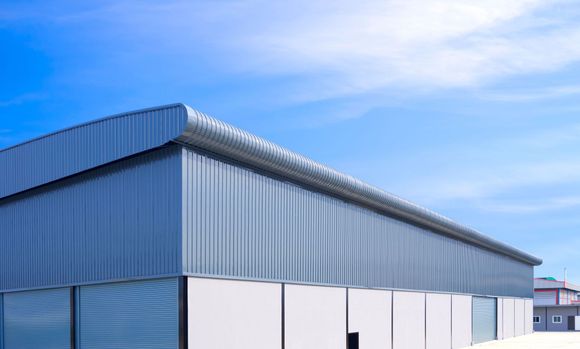 A large metal building with a blue sky in the background.