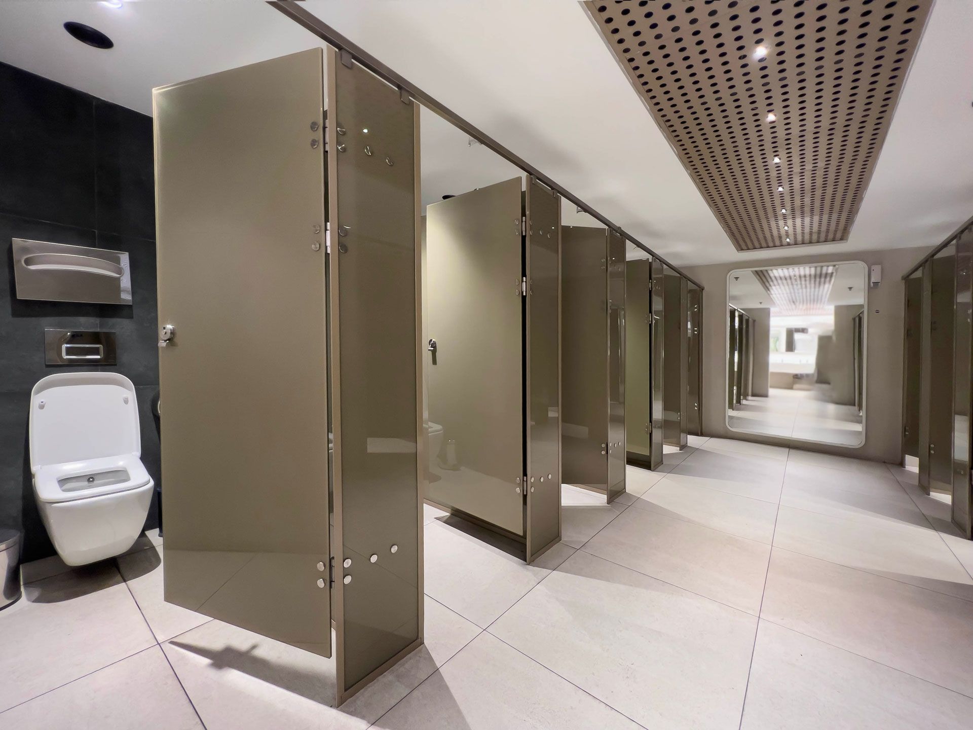 A public restroom with a toilet and a mirror.