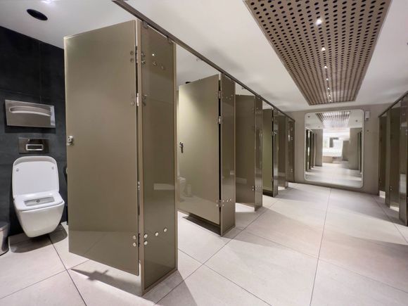 A public restroom with a toilet and a mirror.