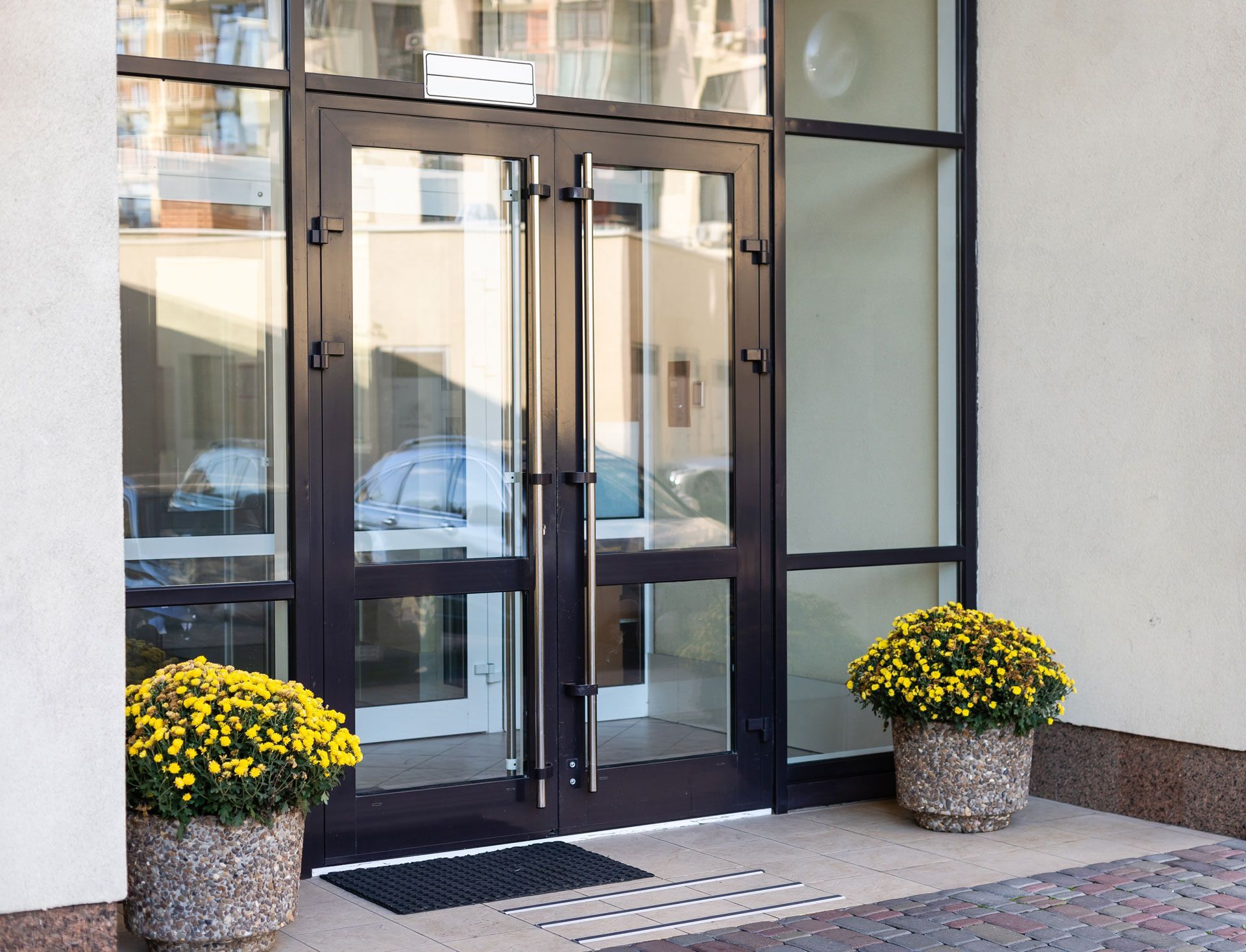 A building with two potted flowers in front of it