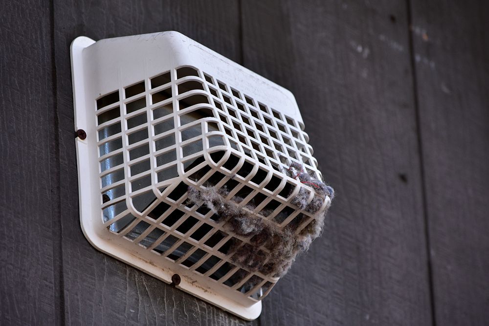A white basket is hanging on a wooden wall.