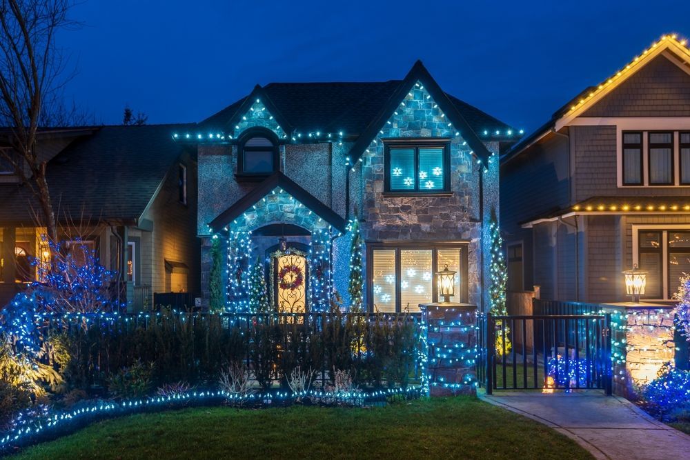 A house is decorated with blue christmas lights at night.