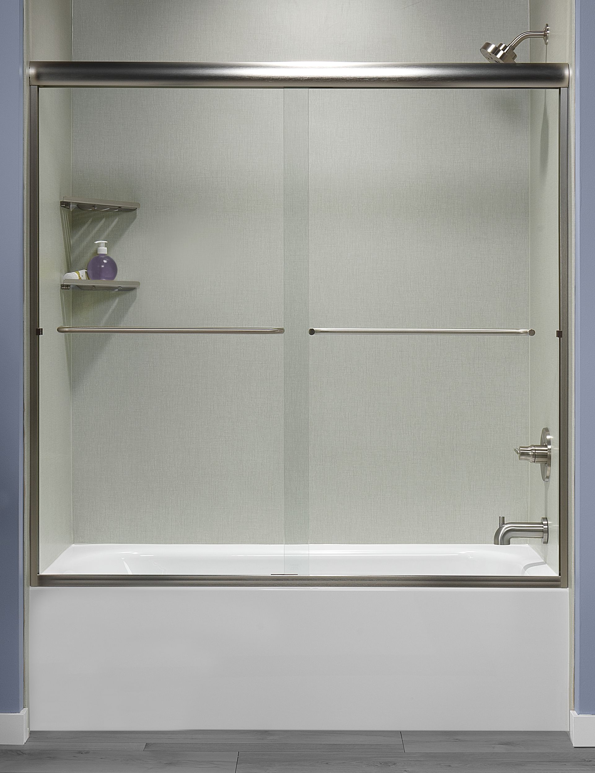 A bathtub with a sliding glass door in a bathroom