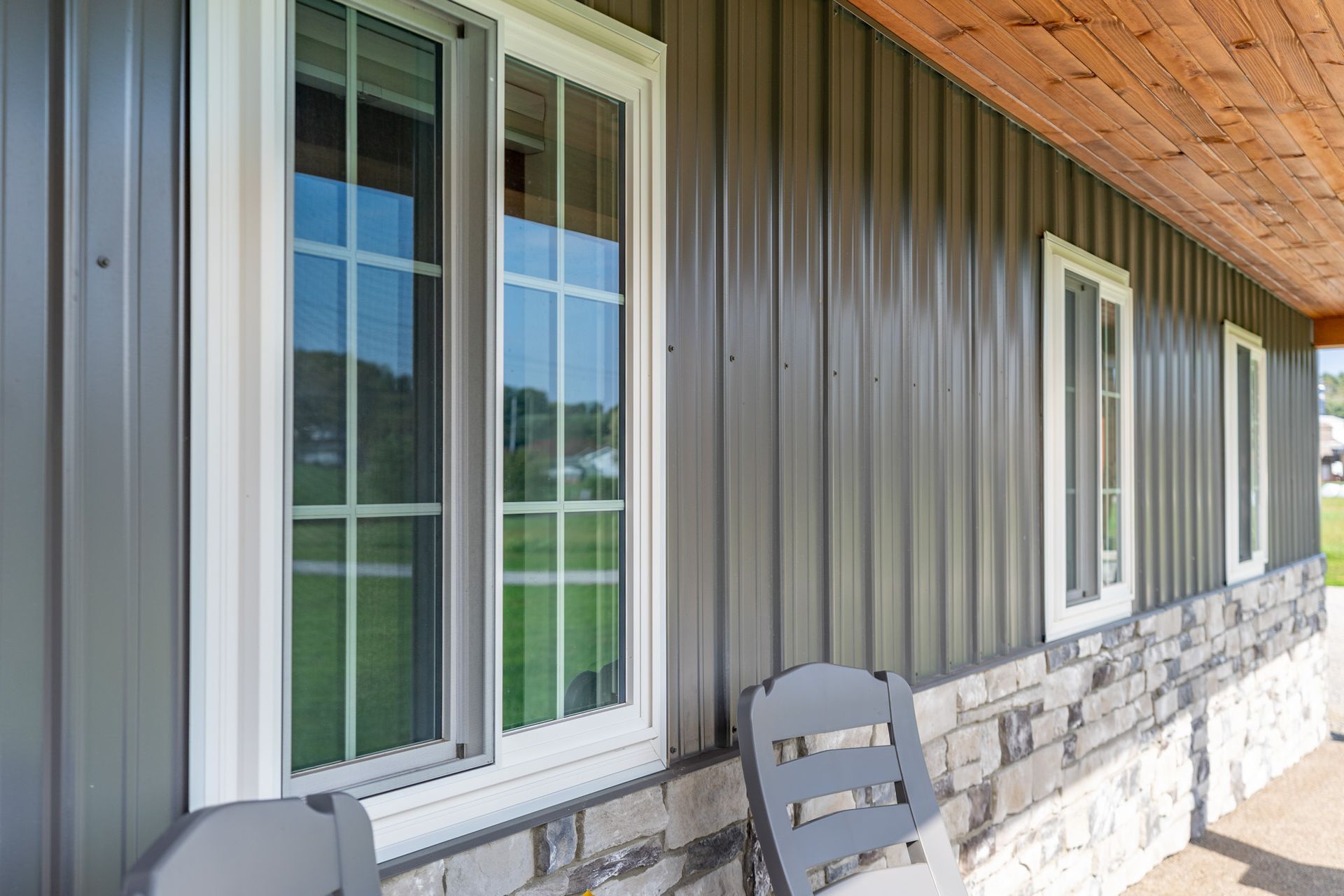 A house with a lot of windows and a chair on the porch.