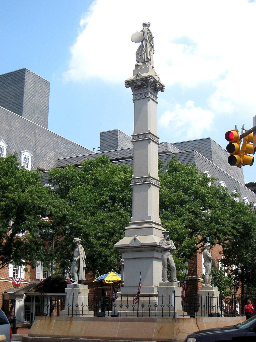 A statue of a woman stands in the middle of a city street