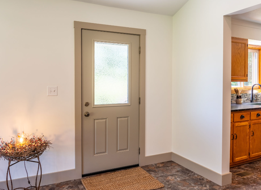 There is a door with a window in the middle of the room.