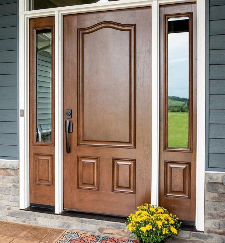 A large wooden door with a reflection of a field in it