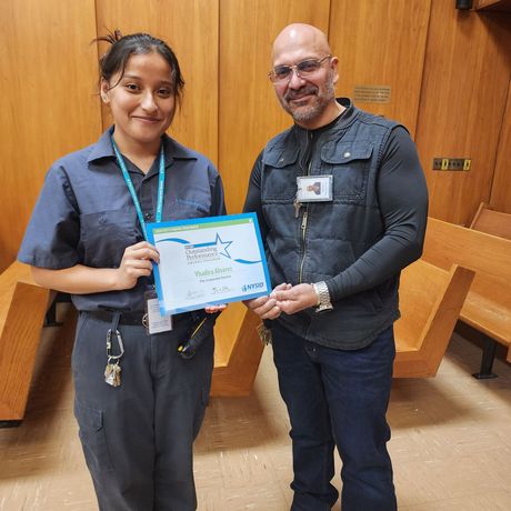 A man and a woman standing next to each other holding a certificate