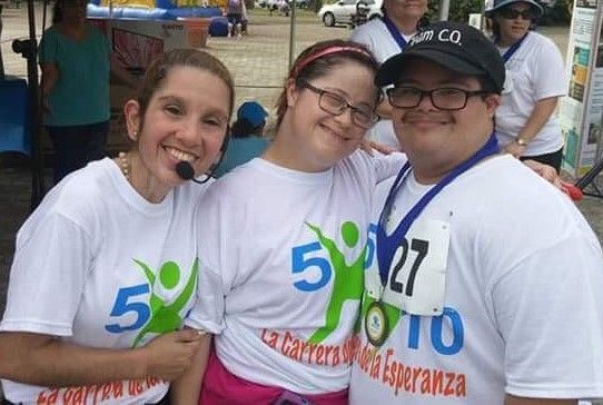 A group of people are posing for a picture and one of them has the number 27 on her shirt