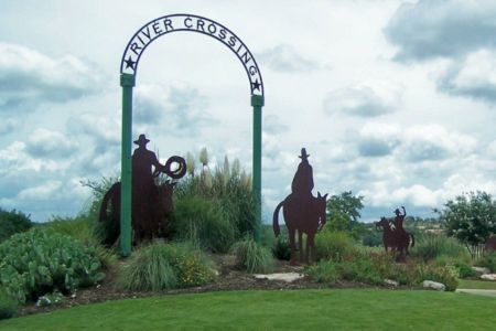 A texas flag is flying in front of a city skyline.