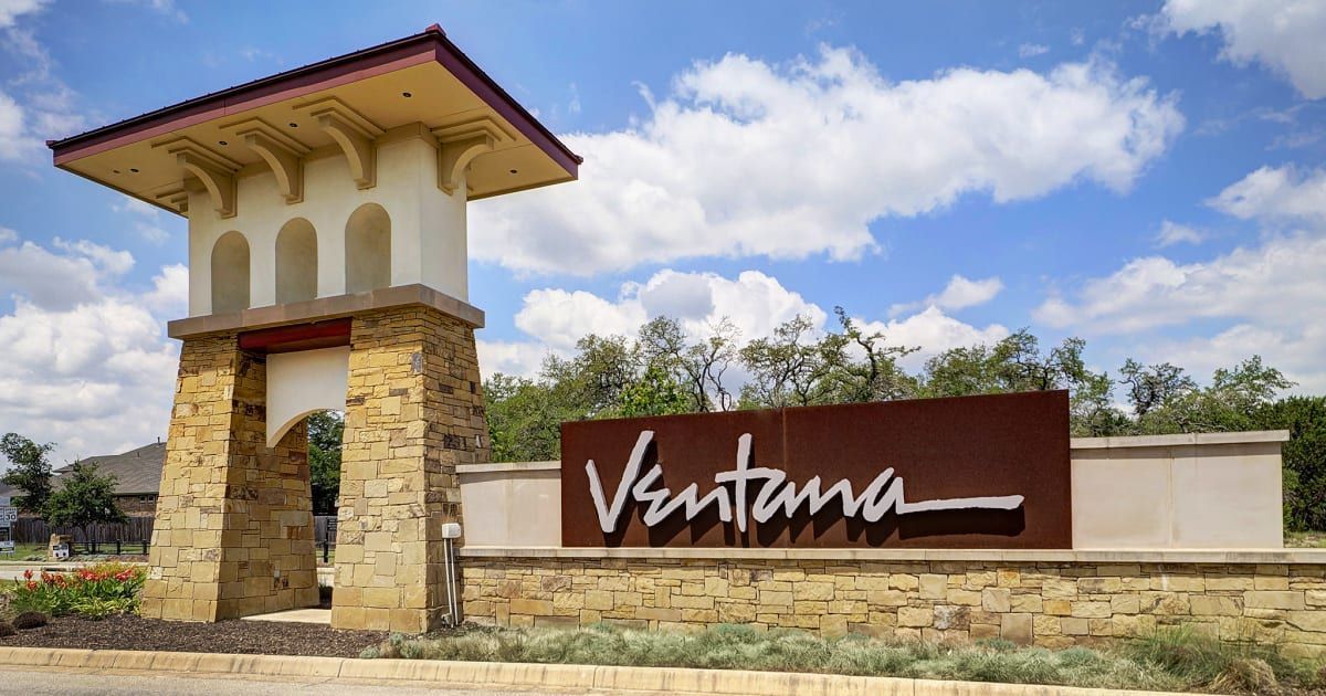 A large building with a clock tower is lit up at night.