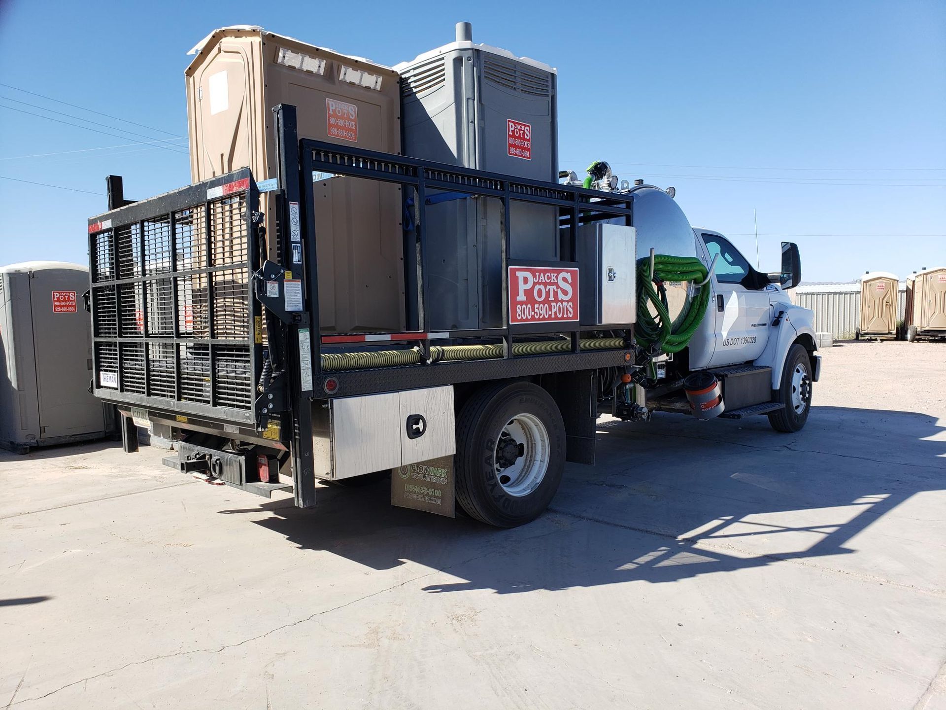 A truck with a cage on the back of it is parked in a parking lot.