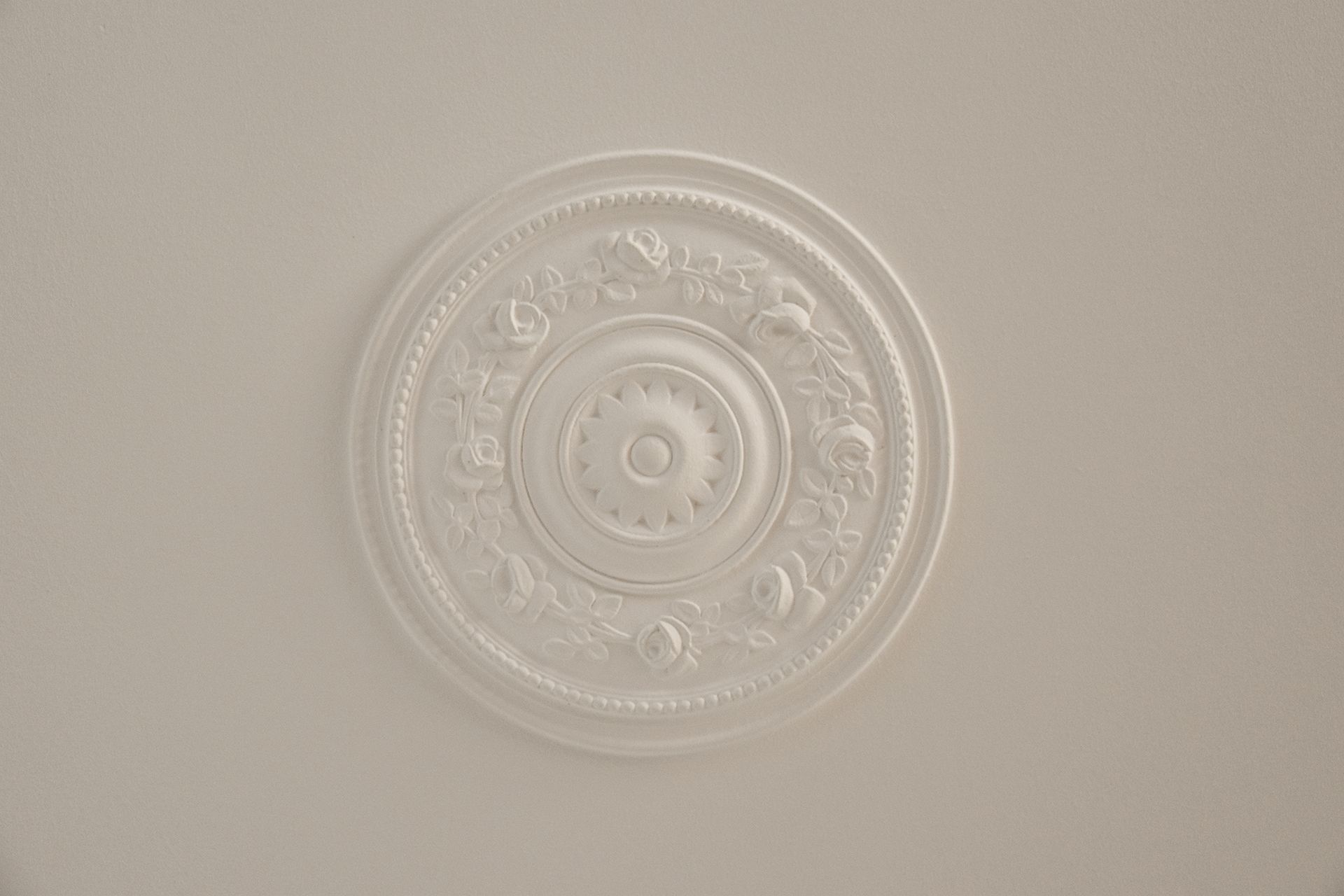 a white circular decoration on a white ceiling