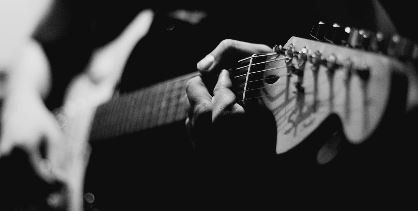 Black and white photo of someone playing the guitar