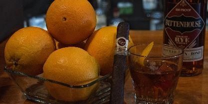Cigar with drinks and oranges