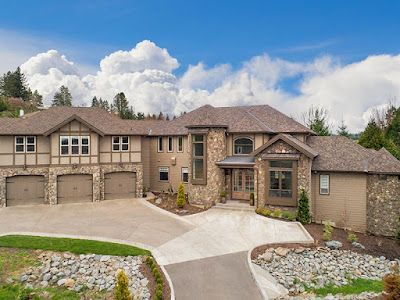 A large house with a lot of garages is sitting on top of a hill.