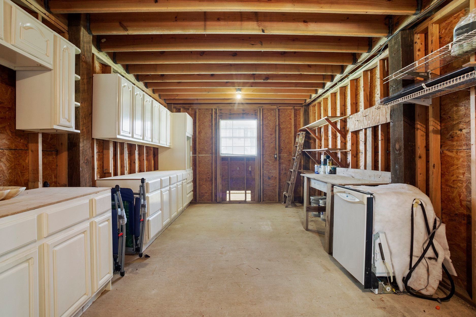 A large room with a lot of cabinets and a washer and dryer in it.