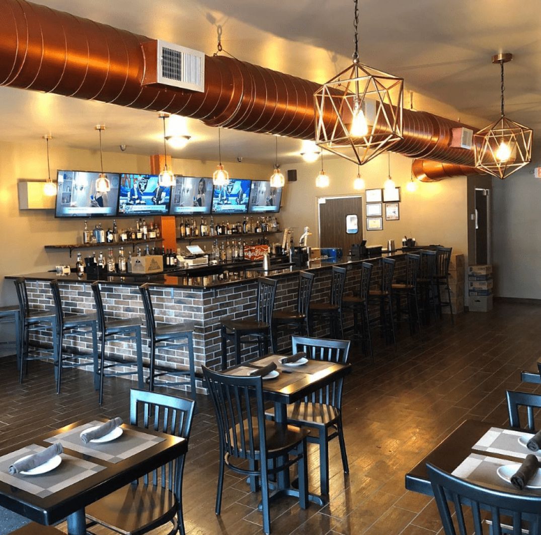 A restaurant with tables and chairs and a bar