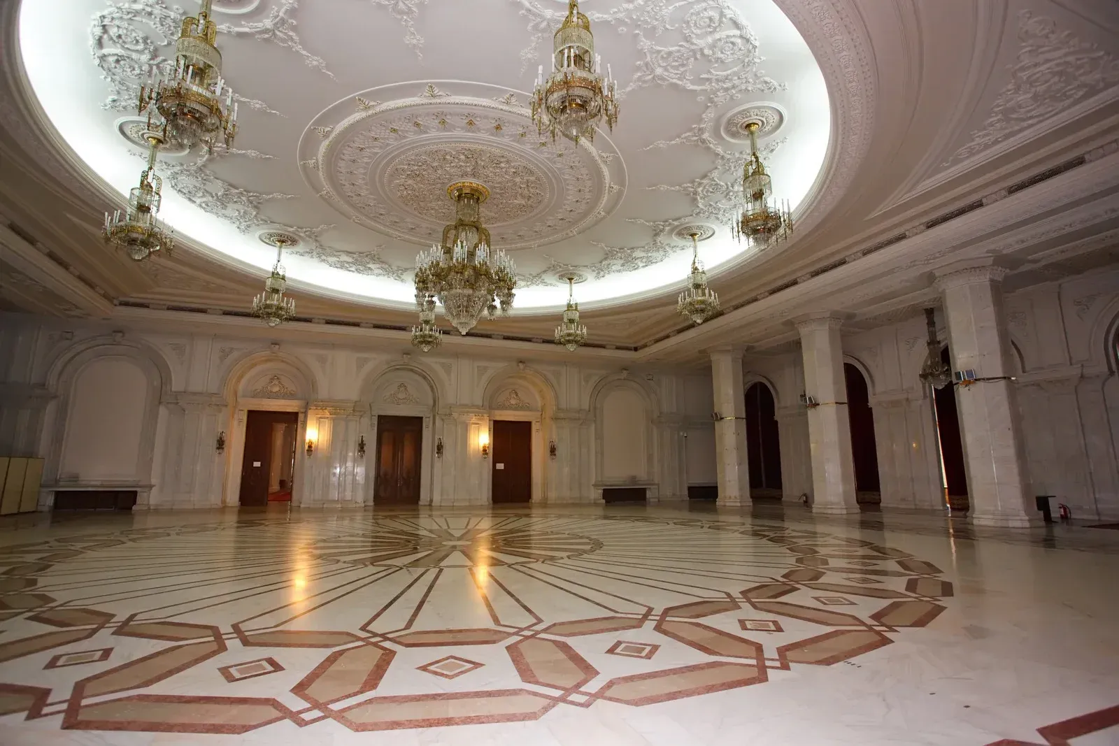 A large empty room with a circular pattern on the floor and ceiling.