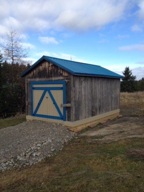 Un hangar avec un toit bleu et une porte bleue