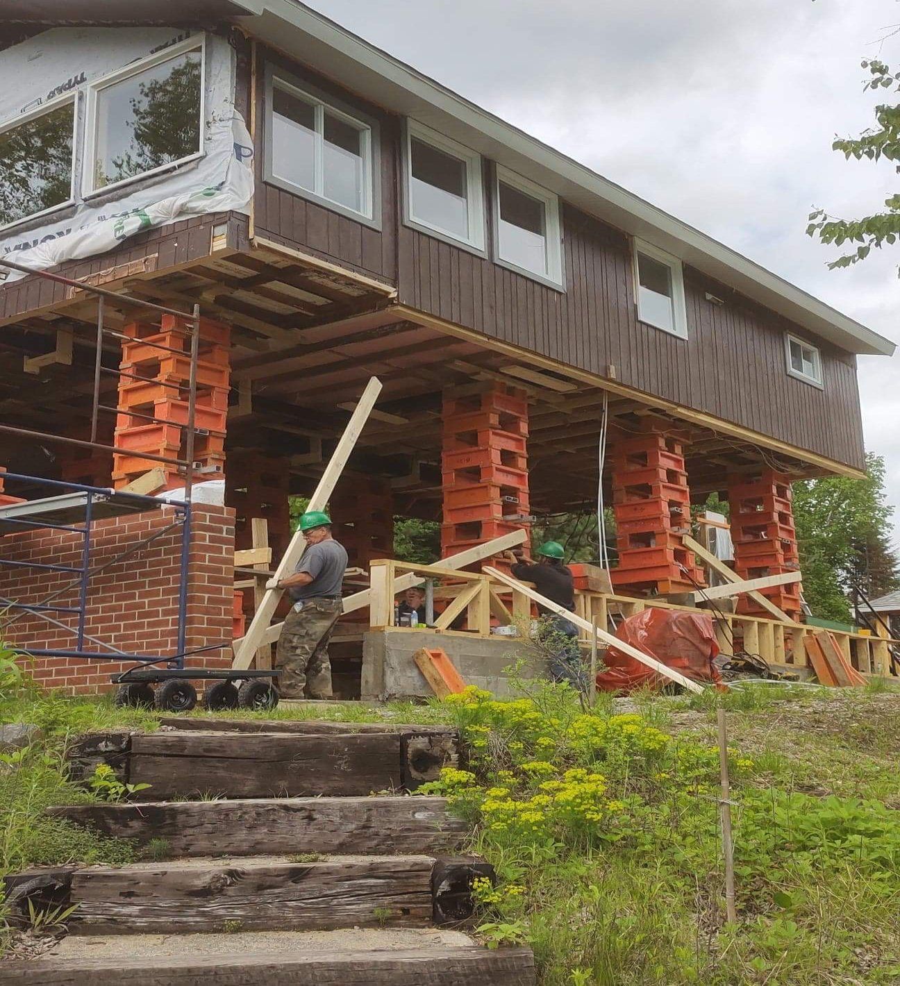Une maison est en construction au sommet d'une colline avec des escaliers qui y mènent.